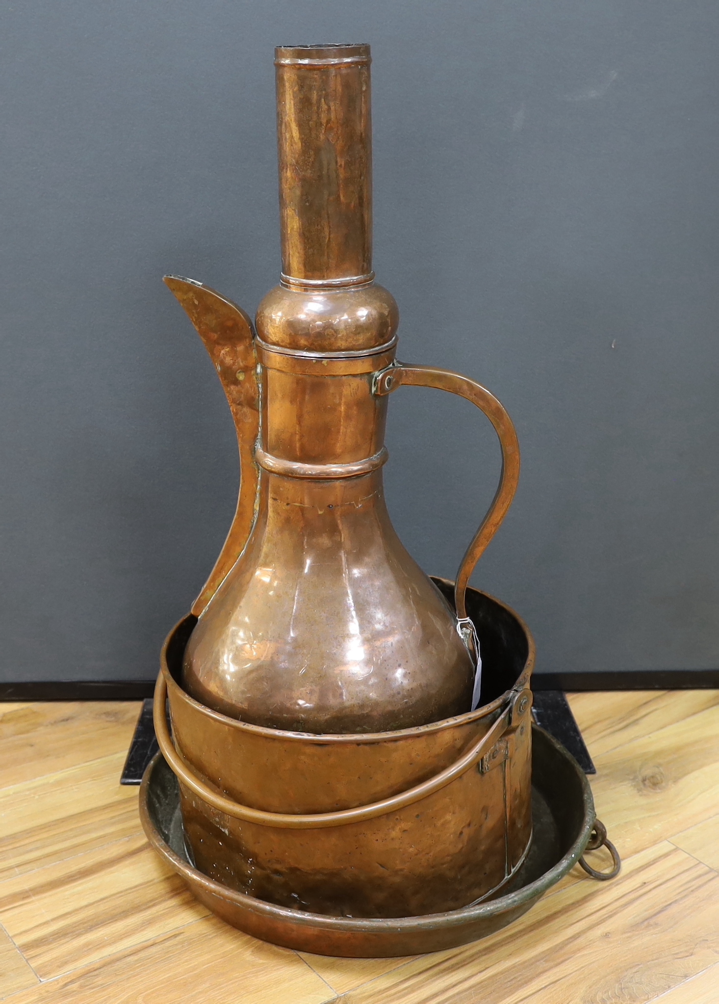 A shallow copper dish a copper cooking pot and a large, Middle Eastern coffee pot,-77cm high